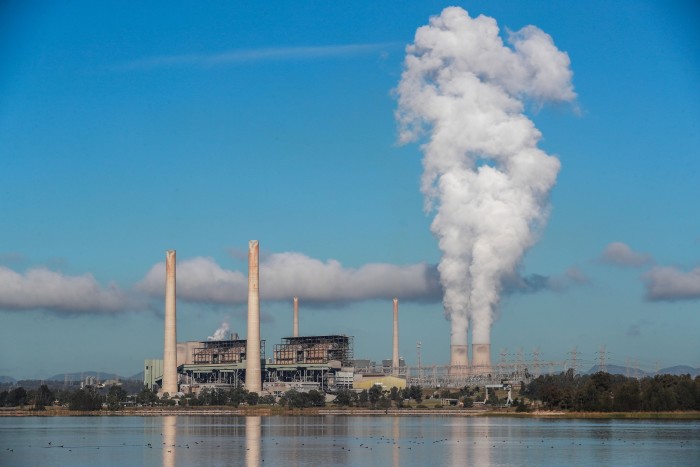 Wide view of Liddell Power Station in Australia with smoke billowing from its towers